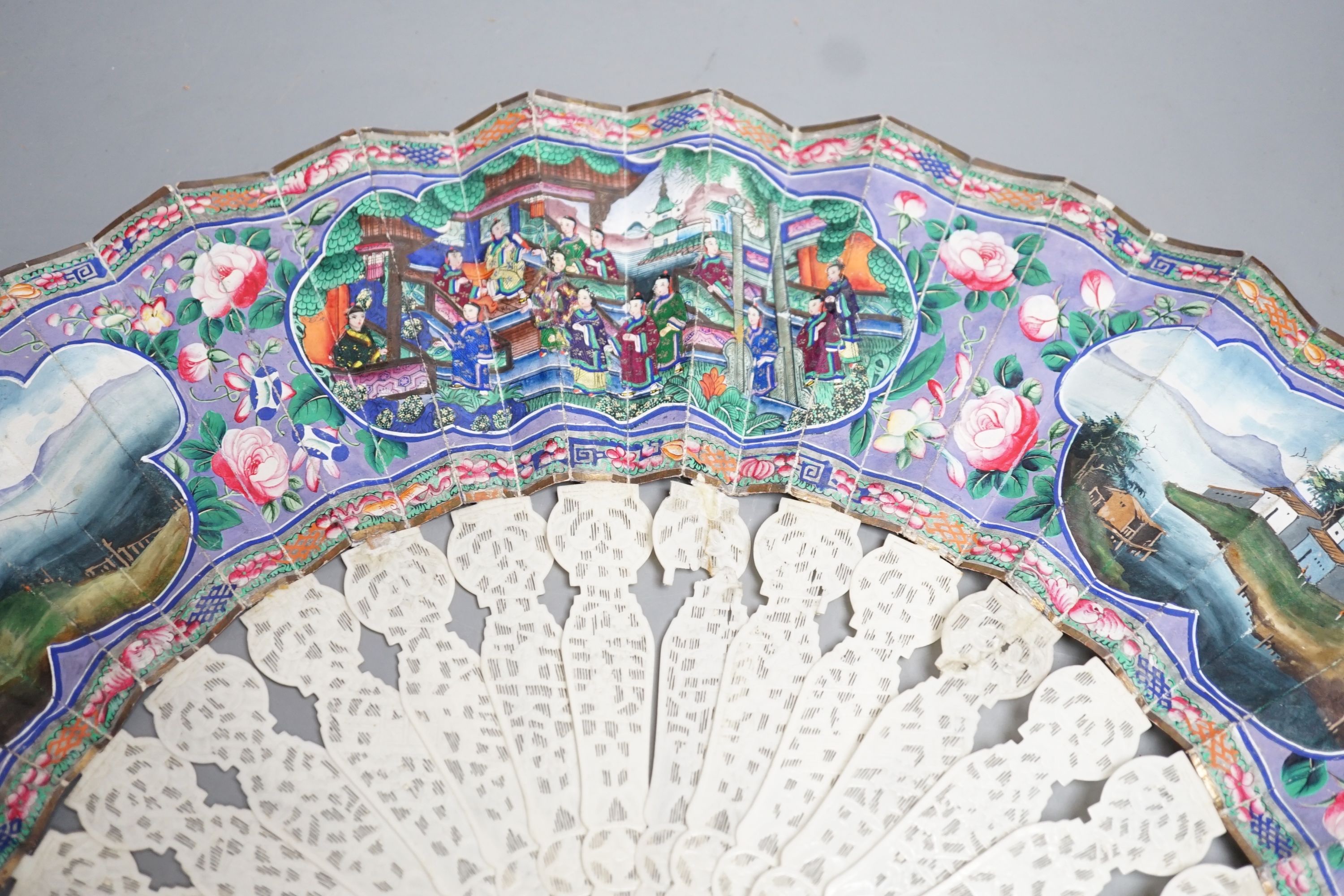 A 19th century Chinese export pierced ivory and painted paper leaf fan, in box. Fan 28cm long